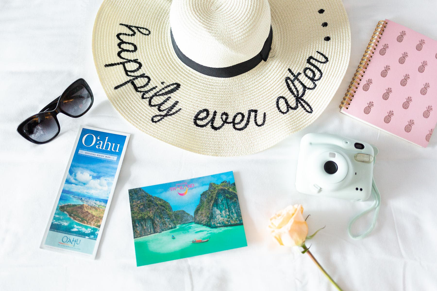 happily-ever-after-hat-travel-items Kalie Daniel Travel Co. personal branding photography with details including a small globe, flowers, and a travel agent mug