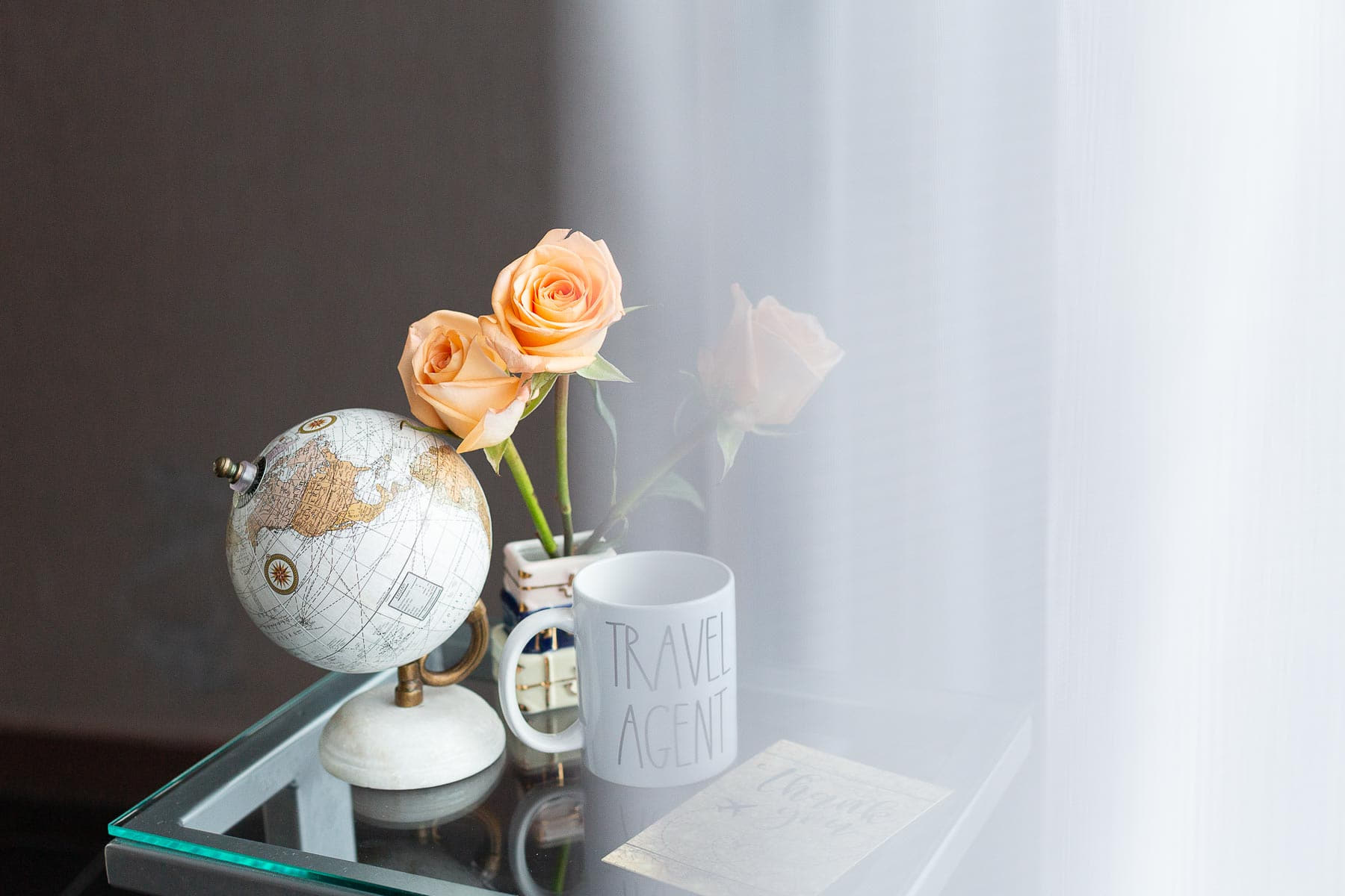 Kalie Daniel Travel Co. personal branding photography with details including a small globe, flowers, and a travel agent mug Kalie Daniel Travel Co. personal branding photography with details including a small globe, flowers, and a travel agent mug